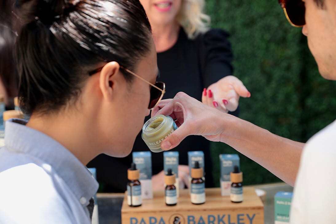 Woman smelling Papa & Barkley calming balm at From The Earth