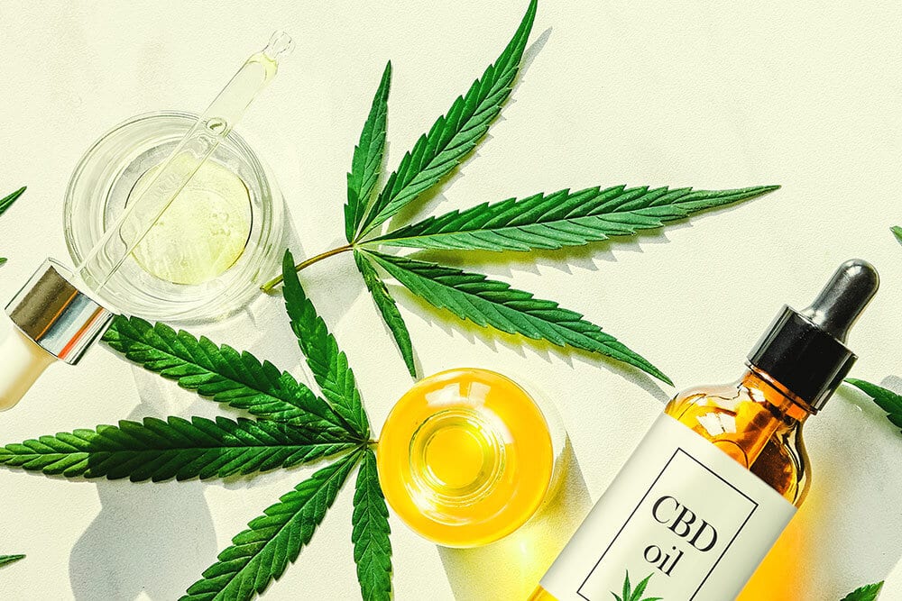 CBD oil, marijuana leaves and CBD tinctures, CBD beauty products