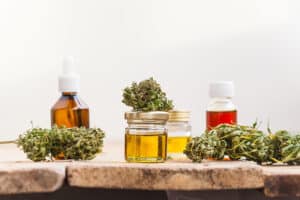 Cannabis flowers and cannabis extracts in jars and tinctures on wooden table