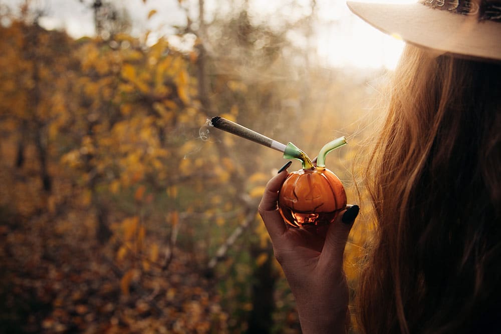 Woman outside during fall holding a pumpkin pipe