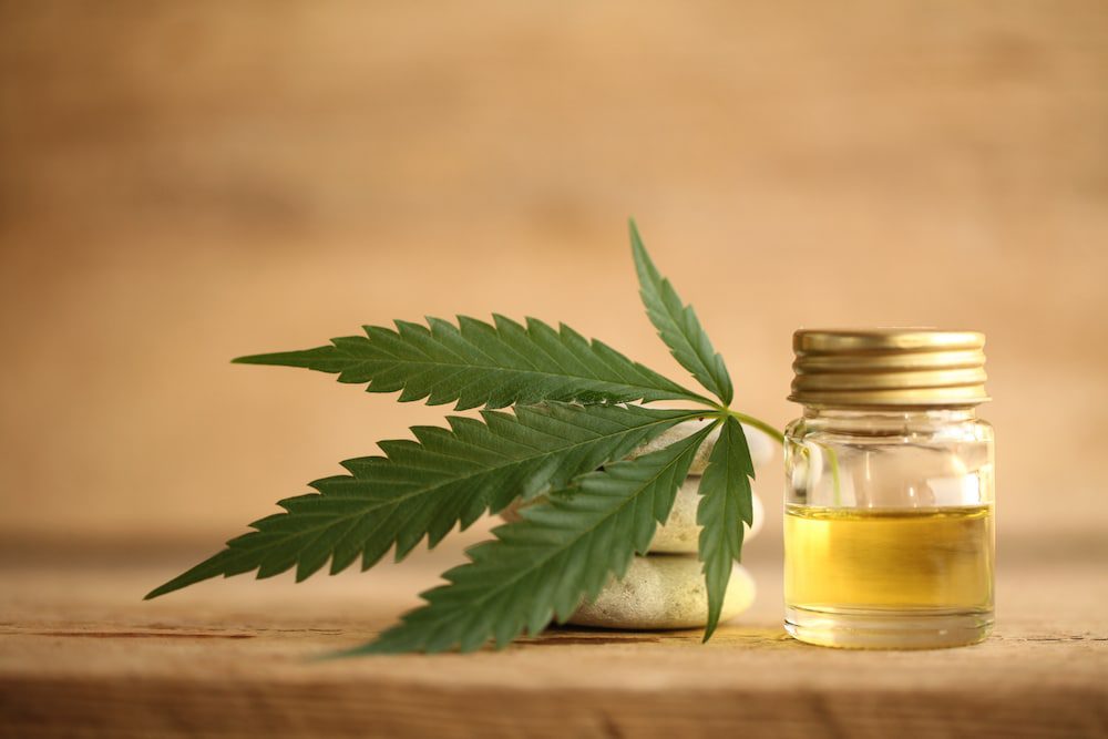 A jar of CBD oil with a cannabis leaf