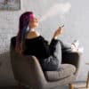 A woman smoking cannabis in a chair