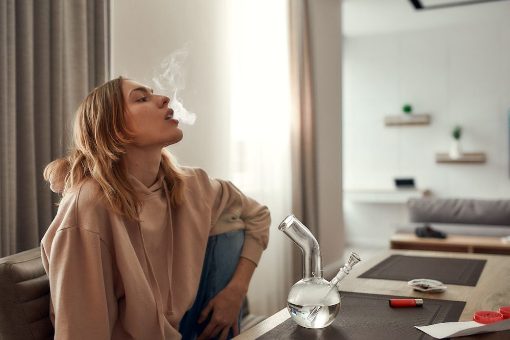 A young woman smoking a bong