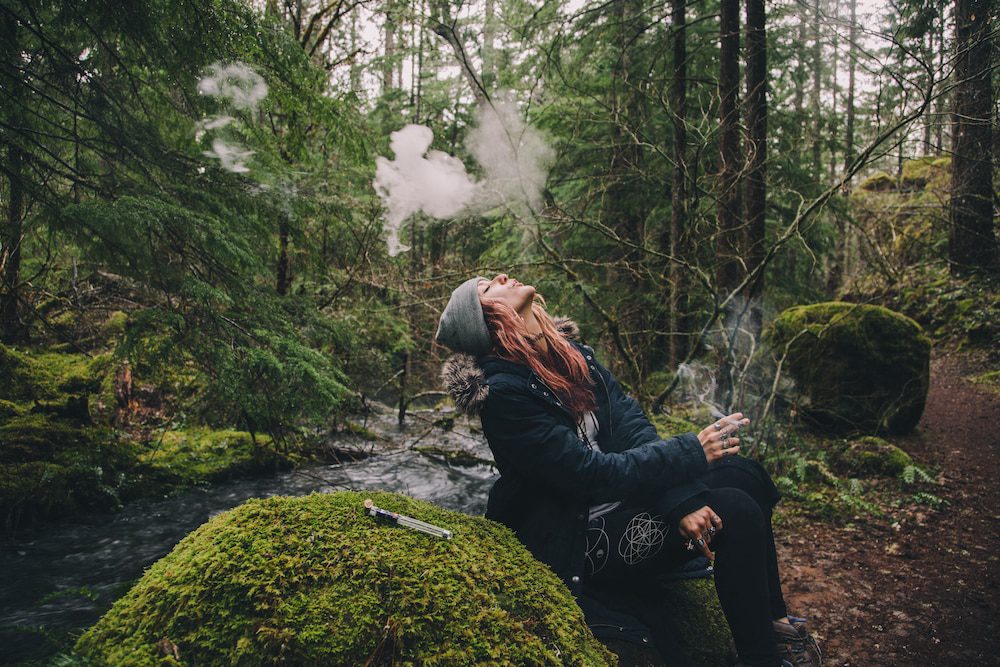 A woman smoking weed while out on a hike