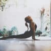A young woman doing a yoga pose out on a patio