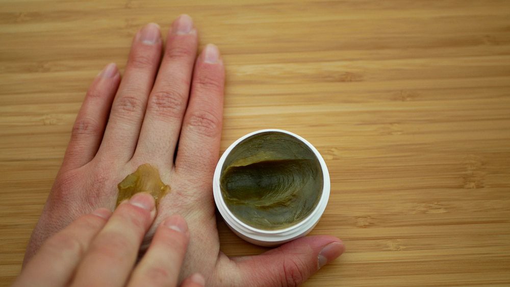 A person using CBD massage cream on their hands