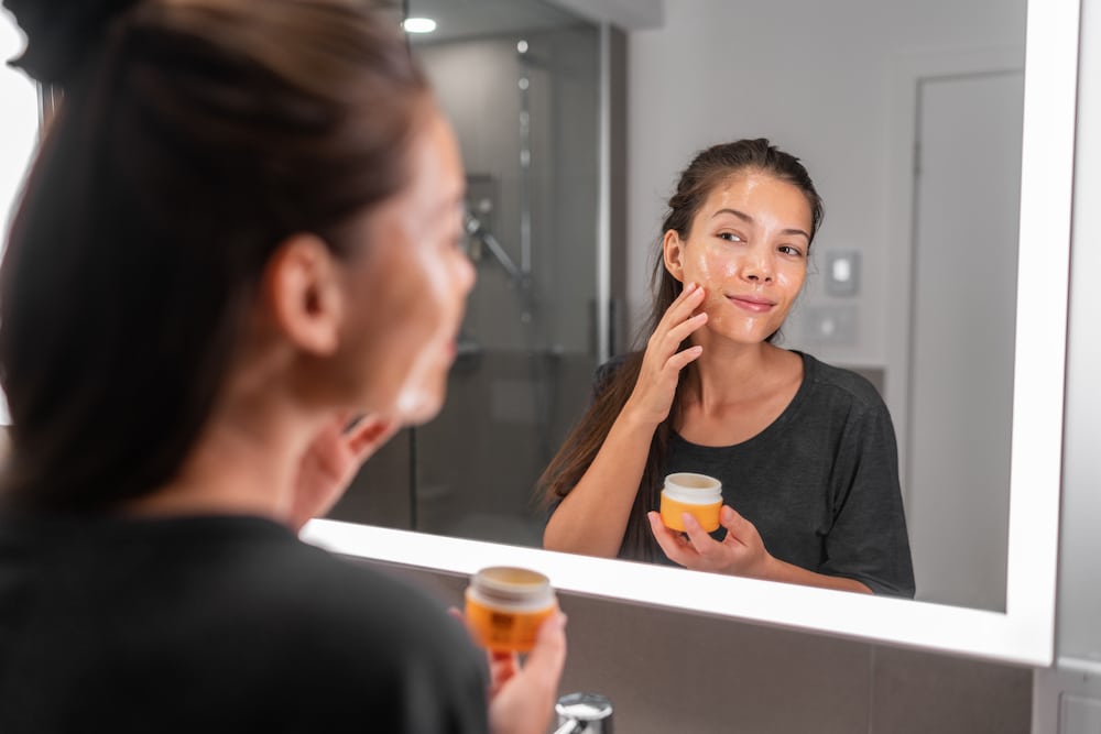 A woman applying skincare cream