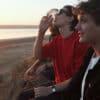 Three friends smoke cannabis by the beach