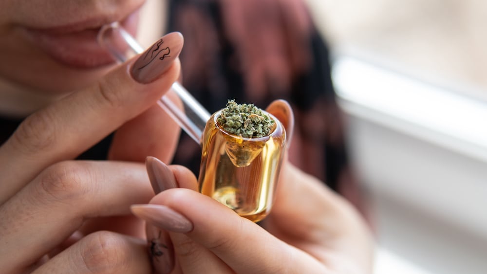 A woman smokes cannabis from a pipe